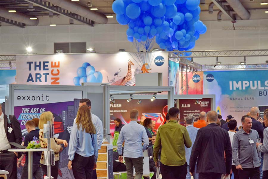 Visitors and exhibitors in the exhibition hall of the DSAG Annual Congress 2025 with impulse stage and motto The Art of Balance