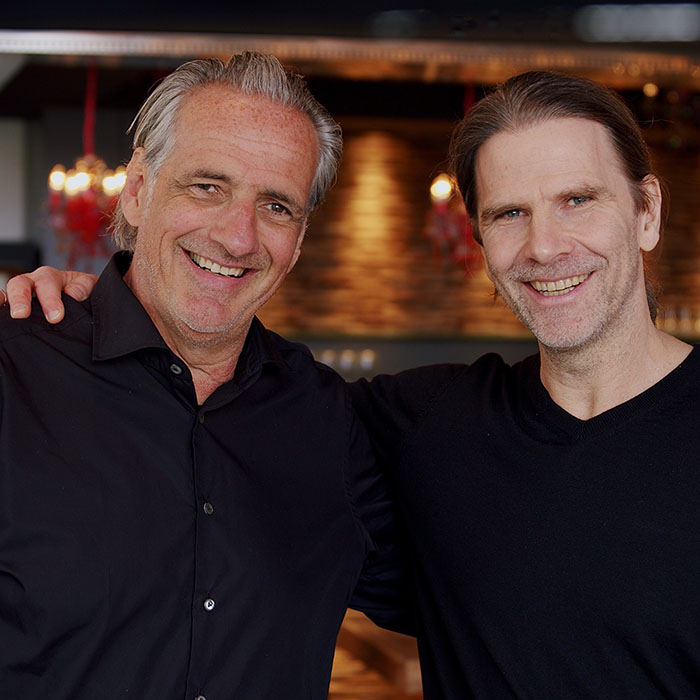 Thilo Kiefer y Michael Struck, los fundadores de Munich Enterprise Software, sonríen juntos a la cámara.